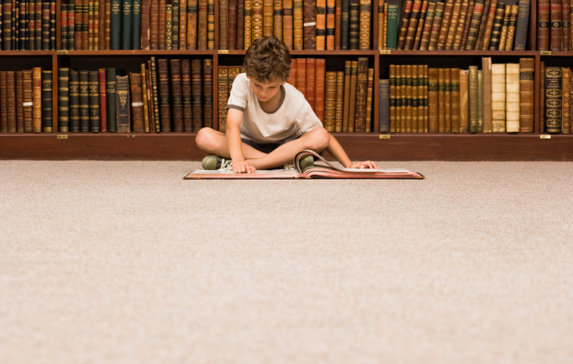 Boy reading book in library
